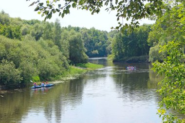 Kar nehri Chernihiv bölgesi / Ukrayna. 21 Temmuz 2020: Bir grup insan güzel bir nehir boyunca kanoyla denize açılıyorlar. Yaz tatili. Yazın nehirde spor ve eğlence. Nehirde kano yapıyorum. Dostlar birlikte vakit geçirir nehirde yelken açarız