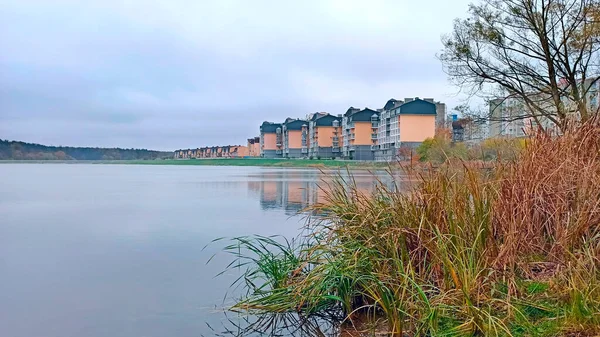 Modern cottages on banks of river. Place of residence. Eco district of city. houses standing on bank of lake. Modern architecture. block of flats. Modern construction. Beautiful urban landscape