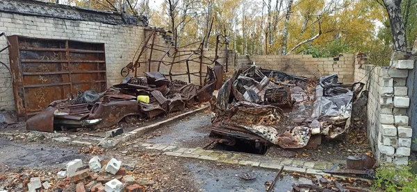 Burnt cars in destroyed garages during war in Ukraine. Destroyed cars. Burnt transport after shelling of Russian army of city in Ukraine. Russian-Ukrainian War. Destroyed buildings and cars during war