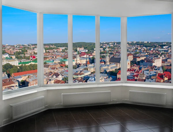 Panoramic window with view of city buildings. Cityscape seen from room window. Beautiful view from room window. Panoramic window overlooking the city houses. Urbanistic view