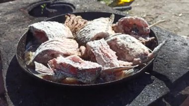 Balık kızartma tavasında kızarır. Taze balık yakalıyorum. Başarılı bir balık avı. Ateşte kızartılmış lezzetli balık yemeği. Kızarmış balığın tabağı ateşte pişiyor. İyi istirahatlar. Balık kızartma parçaları.