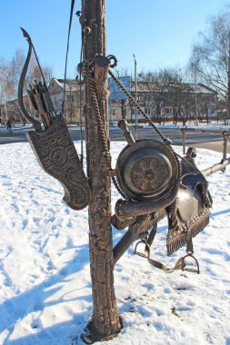 Ancient weapon. Quiver for arrows. Musical horn. Bow and arrows. Saddle and stirrups for riding. Antiquities in sculpture. Ancient monument made of metal. archer equipment