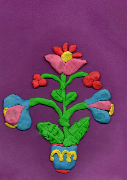 Colorful plasticine flowers on white background. Bright flowers in pot molded from plasticine. Children's work. Plasticine flower on lilac background.