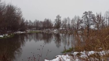 Kış doğada sakin bir hava. Donmuş sahil boyunca akan kış nehri. Su karı temizliyor. Kışın nehir kıyısında. Şubat 'ta gölde çözülmüş su akıyor