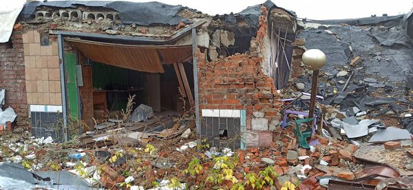 Burnt cars in destroyed garages during war in Ukraine. Destroyed cars. Burnt car after shelling of Russian army in Ukraine. Russian-Ukrainian War. Destroyed buildings and cars during war