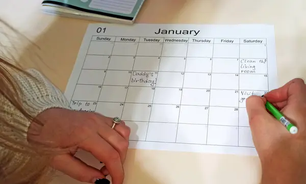 Planner for month. Calendar January. schedule with blank note for to do list on paper background. Human hand filling out to-do list for the month. Empty cells of planner. Monthly organizer. To do list