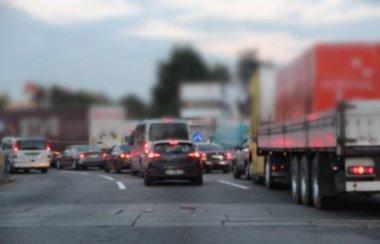 Farları açık arabalar. Ulaşım sinyalleri. Yoldaki araba kuyruğu. Akşam kentinde trafik sıkışıklığı. Nakliye aracı gece trafikte duruyor. Akşam kentinde trafik sıkışık.