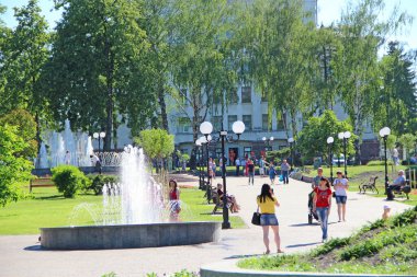 Chernihiv - Ukrayna. 19 Temmuz 2018: Parktaki şehir çeşmeleri. Yaşam tarzı konsepti. İnsanlar şehir parkında fıskiyeli dinleniyor. Güneşli bir yaz günü. Şehir çeşmesinin su jeti. Yaşam tarzı kavramı