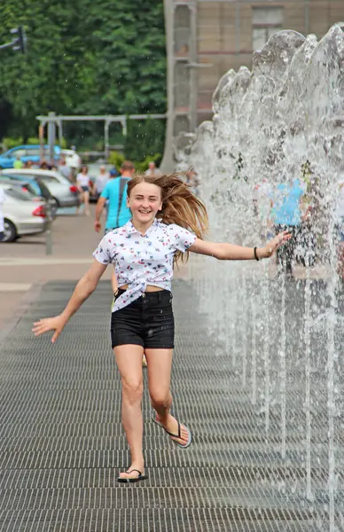 little girl having fun in fountains. Hot summer weather in city. Little girl cooling in fountain in hot weather.