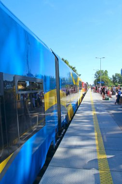 Wladyslawowo - Polonya. 24 Haziran 2019: Modern mavi banliyö treniyle güzel bir tren istasyonu. Modern tren trende ayakta duruyor. Yolcu treni tren istasyonuna gelir.