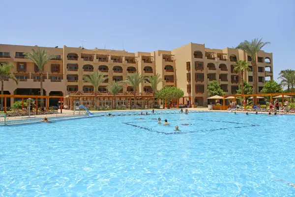 stock image Hurghada - Egypt. 30 July 2018: Tropical resort in Egypt. People swimming in sea. Tourists relax on beach. People enjoy vacations on seaside resort at Red sea. Rest in Hurghada hotel Egyptian resort