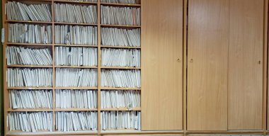 Arşiv belgeleriyle rafta. Bir sürü kağıt. Bir yığın arşiv kağıdı. Müşteriler hakkında bilgi içeren eski bir kart dosyası. Raflardaki kağıt yığınları.