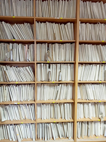 Shelf with archival documents. Lots of papers. pile of archive papers. Old Card file with information about clients. Piles of paper on the shelves