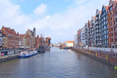 Gdansk - Polonya. 21 Haziran 2019: Gdansk 'ta su kanalının üzerinde duran binaların güzel mimarisi. Gdansk 'ta toprak seti. Şehirdeki bir su kanalı üzerinde modern evler. Polonya şehrinde turistler