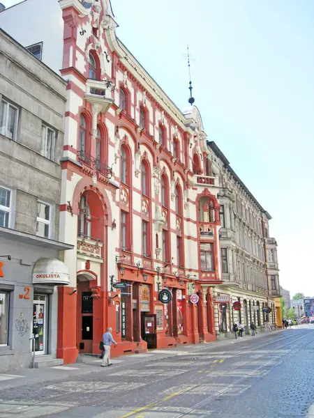 Lodz - Polonya. 17 Ağustos 2019: Lodz 'un güzel mimarisi. Polonya 'nın Lodz şehrindeki binalar. Ofis binası Yaya geçidi. Şehir trafiği. Lodz Caddesi. Şehir kaldırımında yürüyen yayalar..