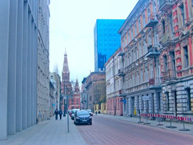 Lodz - Polonya. 27 Temmuz 2019: Lodz 'un güzel mimarisi. Polonya 'nın Lodz şehrindeki binalar. Ofis binası Şehir trafiği. Lodz Caddesi. Şehir kaldırımında yürüyen yayalar..