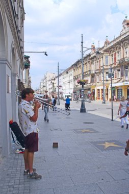 Gdansk, Polonya - 21 Haziran 2019: Adam şehir merkezinde trompet çalıyor. Gdansk 'ta trompet çalan müzisyen. Borazan trompet çalarak geçimini sağlıyor. Açık havada müzik. Trompetçi çalıyor