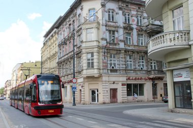 Lodz - Polonya. 18 Haziran 2019: Belediye taşımacılığı. Lodz caddesindeki kırmızı tramvay. Popüler turistik ulaşım. Şehir boyunca giden renkli tramvay. Modern yolcu taşımacılığı