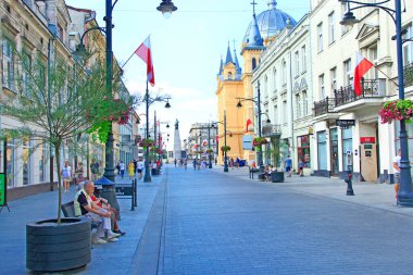 Lodz - Polonya. 27 Temmuz 2019: Lodz Piotrkowska 'nın merkez caddesi, gündüz. Polonya 'nın ana turistik caddesi Lodz Piotrkowska. Piotrkowska caddesindeki Lodz 'da insanlar dinleniyor. Kafede insanlar rahatlar.