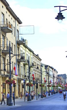Lodz - Polonya. 27 Temmuz 2019: Lodz Piotrkowska 'nın merkez caddesi, gündüz. Polonya 'nın ana turistik caddesi Lodz Piotrkowska. Piotrkowska caddesindeki Lodz 'da insanlar dinleniyor. Kafede insanlar rahatlar.