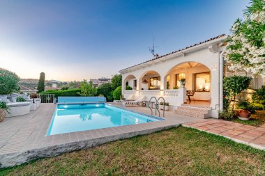 a poolside garden view of a villa along the Costa Del Sol during sunset 