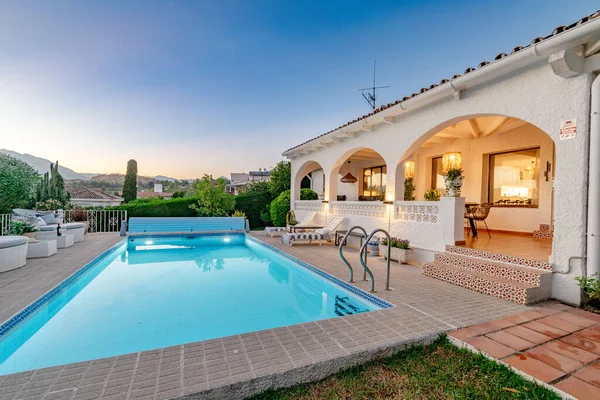 a poolside garden view of a villa along the Costa Del Sol during sunset close up