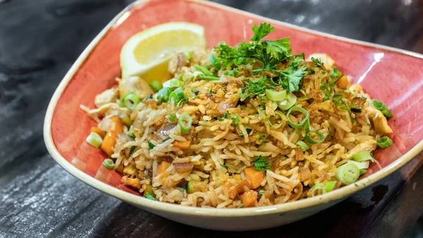 Bir kase taze hazırlanmış doğu usulü karides kızarmış pirinç limon dilimli kırmızı bir kasede servis edilir. 