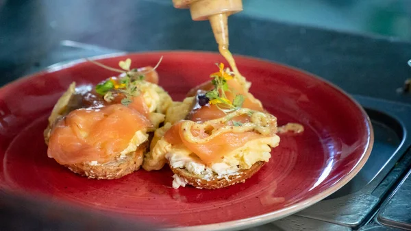 用蜂蜜和芥末调料淋上烤面包的新鲜熏鲑鱼和炒鸡蛋 — 图库照片