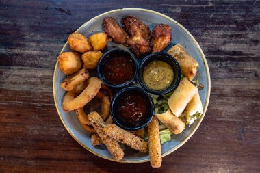 Kızarmış meze tabağının kuş bakışı görüntüsü çeşitli soslarla servis edilen karışım..