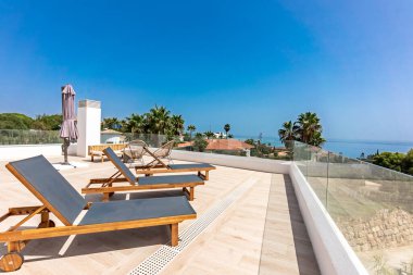 Güneş pansiyonları ve okyanus manzaralı lüks bir teras.