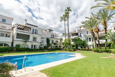 Akdeniz kıyısındaki bir yüzme havuzundaki manzara resmi.