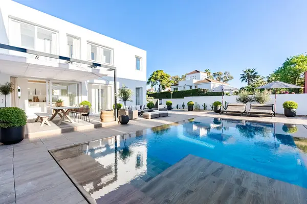 Lüks bir Akdeniz malikâne bahçesi, çeşitli koltukları ve sonsuz havuzu var. 