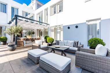 Lüks bir Akdeniz malikanesinde, mobilyalarla dolu bir bahçenin görüntüsü.