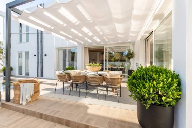 Lüks bir Akdeniz malikanesinin bahçesindeki açık hava yemek masasının görüntüsü.