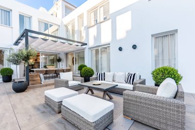 Akdeniz malikanesinin arka bahçesindeki lüks bahçe mobilyalarının görüntüsü.