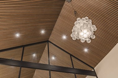 Lüks Akdeniz villasında yeni monte edilmiş ahşap bir tavan ve ışıklandırma sisteminin yakın plan görüntüsü.