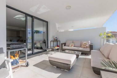 Akdeniz gayrimenkullerinde lüks bir balkon terasında kanepe ve sandalyelerin görüntüsü