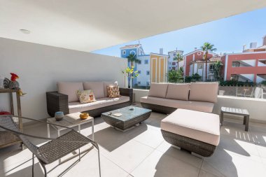Lüks Akdeniz 'deki apartman dairesindeki çeşitli kanepelerin ve sandalyelerin balkon teras görüntüsü.