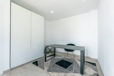 Akdeniz 'de lüks bir yazlık evde siyah masası ve dolapları olan basit bir ofis resmi. 