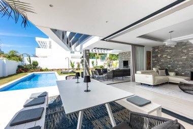 Lüks Akdeniz tatil evinde, özel yüzme havuzunun yanında bir açık hava yemek masası görüntüsü.