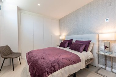 Akdeniz tatil evinde mor çarşaflı büyük bir yatak resmi. 