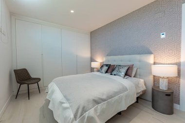 Akdeniz yazlığında büyük yatak lambaları olan basit bir misafir odası görüntüsü. 