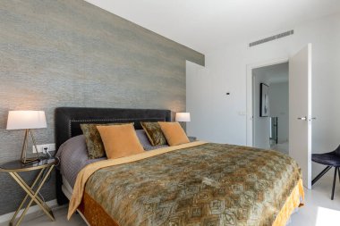 Lüks bir tatil evinin misafir odasında büyük bir yatak resmi. 