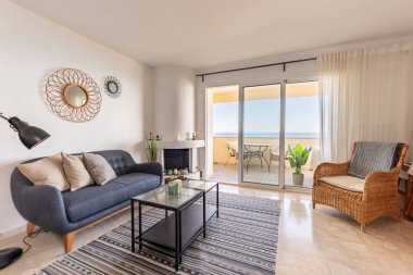 Şömineli ve sahile bakan manzaralı lüks bir Akdeniz oturma odası. 