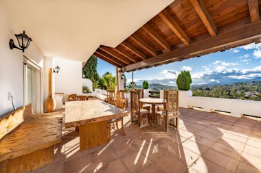 Marbella üzerinde ahşap mobilyalar ve manzara manzaralı lüks bir balkon terası.