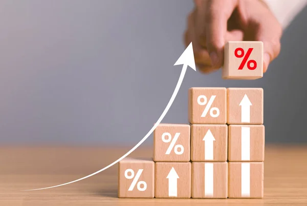 Interest rate financial and mortgage rates concept. Wooden blocks with Icon percentage symbol and arrow pointing up. company business growth and sales, interest rate, tax