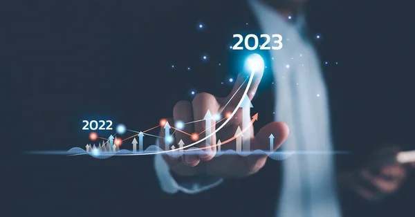 Businessman draws increase arrow graph corporate future growth year 2022 to 2023. Planning,opportunity, challenge and business strategy. New Goals, Plans and Visions for Next Year.