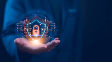Adam, siber güvenlik ve veri korumasını sembolize eden bir kilit sembolü ile parlayan dijital kalkan gösteriyor. Konsept, dijital dünyada güvenli teknoloji ve güvenli veri yönetimini vurguluyor.