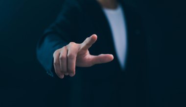 İşadamı boş bir ekrana işaret ediyor ya da dokunuyor, gelecekteki teknolojiyle etkileşimi sembolize ediyor. Yenilik, dijital dönüşüm ve stratejik iş girişimleri. Yapay zeka veya küresel iletişim.