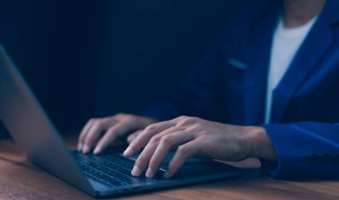 İş adamı hesap makinesi ve not defteriyle dizüstü bilgisayarda daktilo kullanıyor. Ofis işleri, mali yönetim, veri girişi ve modern işletmeler. Uzak çalışma, dijital iletişim.